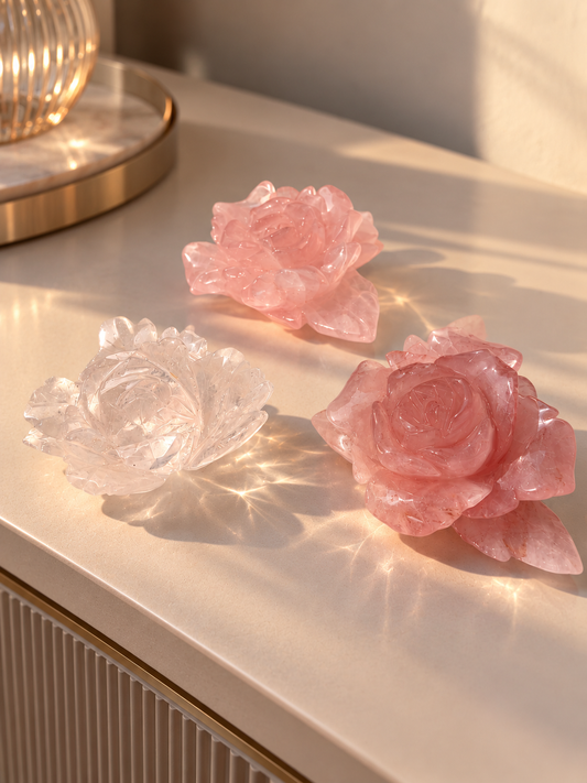 Drei handgefertigte Kristallrosen aus Brasilien: zwei rosa Rosenquarz-Rosen und eine klare Bergkristall-Rose