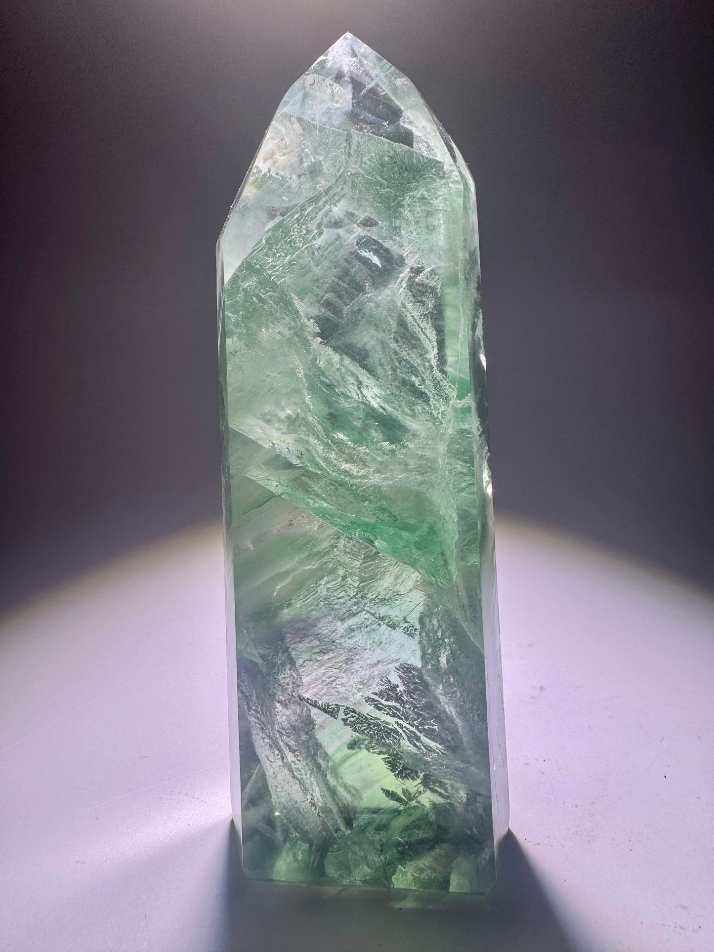 Extraklare mintgrüne Fluoritspitze mit zarten Phantomlinien und Regenbogenreflexen