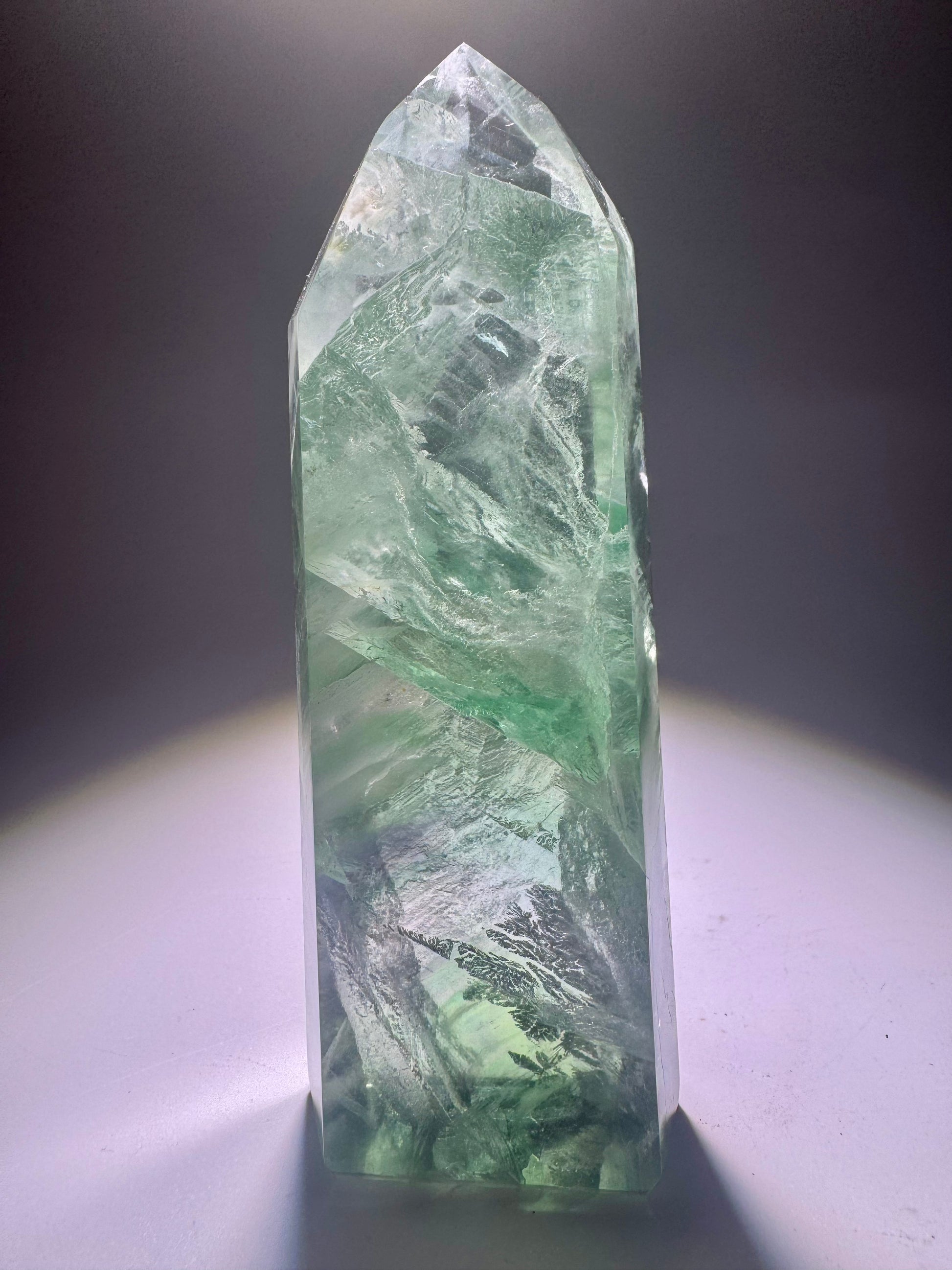 Extraklare mintgrüne Fluoritspitze mit zarten Phantomlinien und Regenbogenreflexen