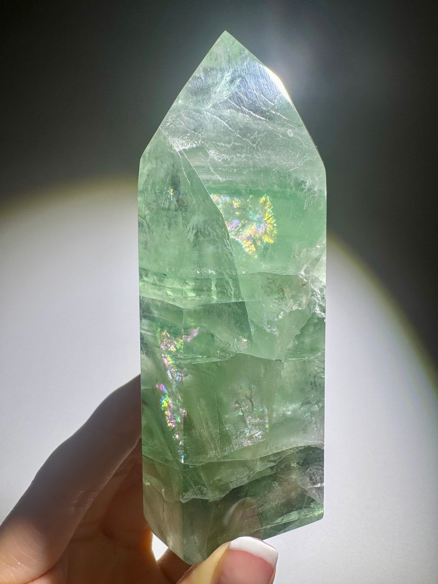 Mintgrüne klare Fluoritspitze mit feinen Phantomlinien und Regenbogenglanz